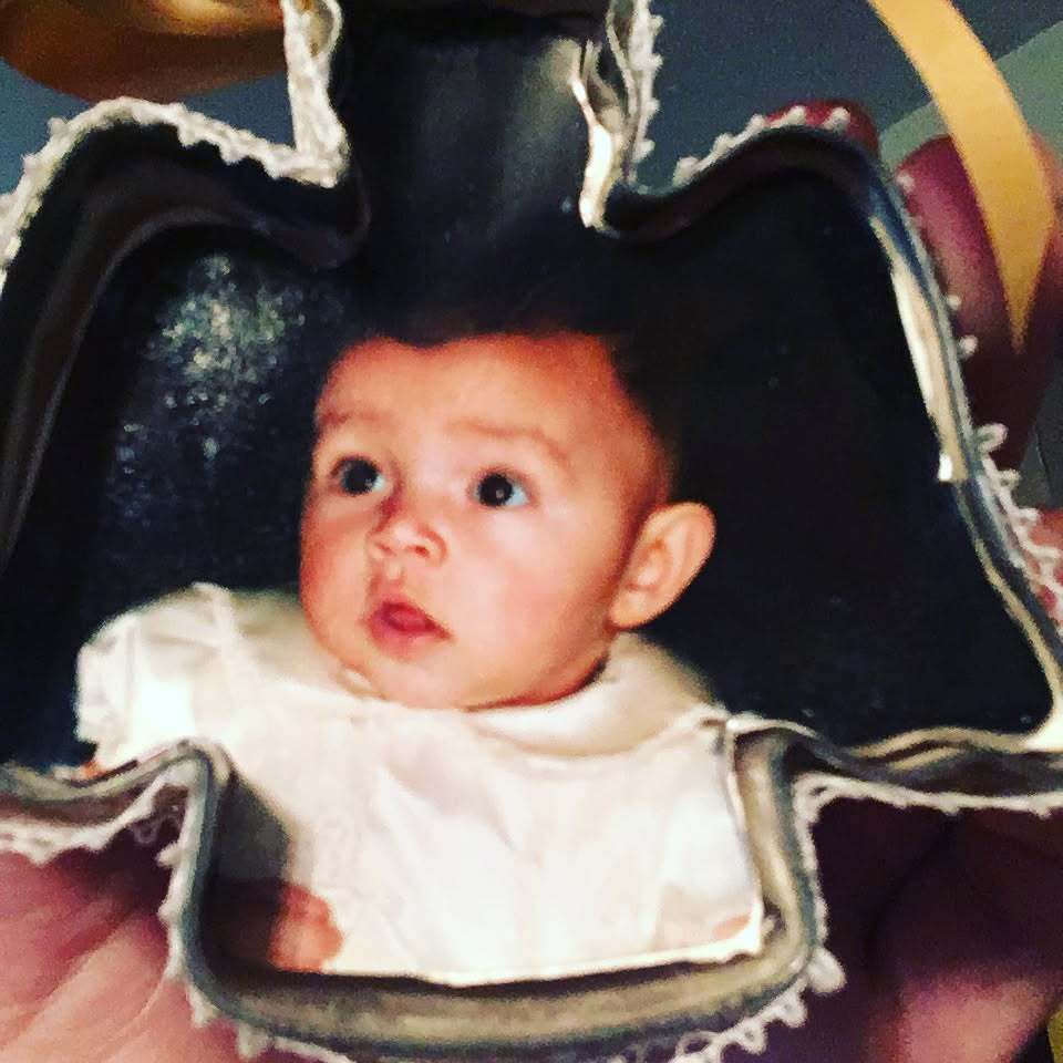 A baby clove photo, as seen cut to fit inside a Christmas ornament.