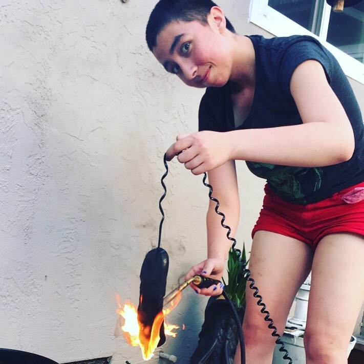 Clover Gardener, age 18, torching a corded telephone to act as a prop for a theatrical performance.